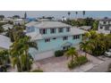 Three-story light blue home with three-car garage at 796 Jacaranda Rd, Anna Maria, FL 34216