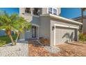 Front entry and garage of two-story house with gray siding and brick walkway at 8430 Nandina Dr, Sarasota, FL 34240