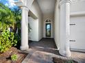 Front entrance with columns, brick walkway, and a modern door at 16528 Berwick Ter, Bradenton, FL 34202