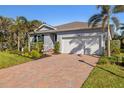 Single-story home with gray exterior, two-car garage, and landscaped front yard at 24748 Rio Villa Lakes Cir, Punta Gorda, FL 33950