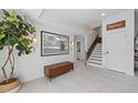 Bright and airy entryway with a stylish bench, large artwork, and staircase at 308 S Bay Blvd, Anna Maria, FL 34216