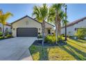 House exterior with a dark brown garage door and lush green landscaping at 364 Palmaria Ct, Nokomis, FL 34275