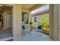 Relaxing front porch with two rocking chairs, a small table, and potted plants at 364 Palmaria Ct, Nokomis, FL 34275