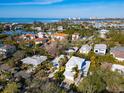 An aerial shot of a house near the coast, surrounded by other homes and lush vegetation at 4189 Roberts Point Cir, Sarasota, FL 34242