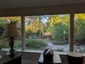 Bright sunroom with expansive windows overlooking a lush garden at 4928 San Jose Dr, Sarasota, FL 34235