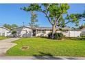 Single story home with driveway, lawn, and large shade tree at 6227 Pauline Ave, Sarasota, FL 34231