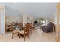 Open living and dining area with tile floors and access to screened patio at 6703 Midnight Pass Rd # 117, Sarasota, FL 34242