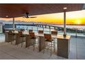 Rooftop deck featuring a long counter with seating and stunning sunset views of the bay and bridge at 111 Golden Gate Pt # 403, Sarasota, FL 34236