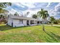House exterior showcasing a well-maintained lawn and palm trees at 13479 Newport Ave, Port Charlotte, FL 33981