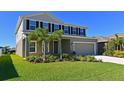 Two-story house with gray siding, black shutters, landscaping, and a large lawn at 6107 116Th E Ave, Parrish, FL 34219