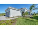 Single-story home, gray exterior, landscaped yard, paved walkway at 10142 Crystal Isles Cir, Sarasota, FL 34241