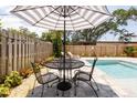 Relaxing patio with bistro table set and umbrella, near pool at 2820 Novus St, Sarasota, FL 34237