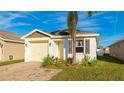 Inviting single-story home with yellow door and shutters, a neatly maintained lawn, and brick driveway at 4107 11Th E St, Bradenton, FL 34208