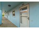 Exterior view of building showing light blue walls and a white door at 4307 Gulf Dr # 103, Holmes Beach, FL 34217