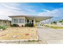 Tan mobile home with covered carport and manicured landscaping at 5619 Bayshore Rd # 365, Palmetto, FL 34221