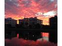 Stunning sunset view of waterfront community with three-story buildings at 7830 34Th W Ave # 102, Bradenton, FL 34209