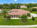 Single-Gathering home with tile roof, landscaping, and a palm tree in front at 8356 Mareva Ln, Sarasota, FL 34241