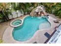 Irregular shaped pool with a waterslide and spa at 106 7Th S St, Bradenton Beach, FL 34217