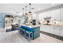 Bright kitchen boasts granite countertops, stainless appliances, white cabinets, and a center island with bar stool seating at 17335 Polo Trl, Bradenton, FL 34211