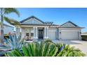 Gray house with two-car garage and lush landscaping at 1825 Twin Rivers Trl, Parrish, FL 34219