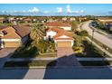 Single-Gathering home in a residential community with a lake and palm trees at 20680 Vita Ct, Venice, FL 34293