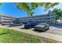 Exterior view of a multi-story condo complex with a well-maintained parking lot and landscaped grounds at 2435 Sumatran Way # 35, Clearwater, FL 33763
