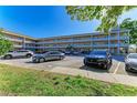 Exterior view of a multi-story condo complex with a well-maintained parking lot and landscaped grounds at 2435 Sumatran Way # 35, Clearwater, FL 33763