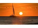 Silhouette of a sailboat at sunset over the ocean at 415 L Ambiance Dr # A801, Longboat Key, FL 34228