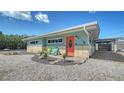 Charming beach house featuring colorful accents, well-kept landscaping, and a covered carport at 4626 Gleason Ave, Sarasota, FL 34242