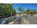 Professionally landscaped yard with gravel, stones and tropical plants, creating a serene outdoor space at 4626 Gleason Ave, Sarasota, FL 34242