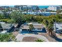 Aerial view of a home nestled among trees, with a circular driveway and glimpses of nearby buildings at 6536 Sabal Dr, Sarasota, FL 34242
