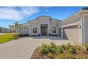 Front view of a single-story house with gray exterior and paver driveway at 12515 Galapagos Ct, Venice, FL 34293