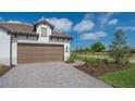 Two-car garage with paver driveway and nicely landscaped front yard at 26903 Pavin Dr, Englewood, FL 34223