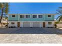Newly constructed three-unit building, featuring light teal exterior and attached garages at 303 65Th St # B, Holmes Beach, FL 34217