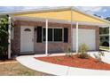 Front view of a brick home with a yellow overhang and walkway at 3345 Bailey St, Sarasota, FL 34237