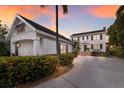 Charming two-story home with white siding, black shutters, lush landscaping, and a detached two-car garage at 4110 Riverview Blvd, Bradenton, FL 34209