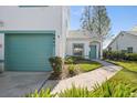 Front view of attached white stucco home with teal garage and walkway at 6640 Pineview Ter # 6640, Bradenton, FL 34203
