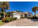 Single-story home features a white exterior, tile roof, and landscaped yard at 7156 Rue De Palisades # 3, Sarasota, FL 34238