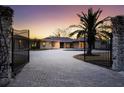 Brick paver driveway with open gates at sunset at 7618 Midnight Pass Rd, Sarasota, FL 34242