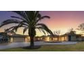 Circular driveway, palm tree, and attached garage at sunset at 7618 Midnight Pass Rd, Sarasota, FL 34242