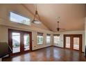 Bright living room with tile flooring, high ceilings, large windows, and French doors leading to the outside at 7806 Ontario Street Cir # 7806, Sarasota, FL 34243