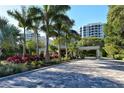 Gated community entrance with lush landscaping and paved driveway at 1211 Gulf Of Mexico Dr # 408, Longboat Key, FL 34228