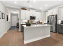 Modern kitchen with gray and white cabinets, stainless steel appliances, and an island at 153 Soliera St, Nokomis, FL 34275