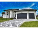 Modern home with a paved driveway and two-car garage at 230 W Pine Valley Ln, Rotonda West, FL 33947