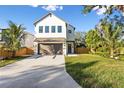 Modern two-story home with a white exterior, attached garage, and landscaped lawn at 2554 Arlington St, Sarasota, FL 34239