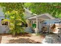 Inviting front porch with seating area, under a large tree at 2574 Hawthorne St, Sarasota, FL 34239