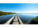 Serene waterfront view with a wooden dock extending into the water at 3705 E Bay Dr # 212, Holmes Beach, FL 34217