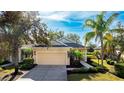 One-story house with yellow walls, green door, and a two-car garage, nestled in a residential community at 5032 Newport News Cir, Bradenton, FL 34211