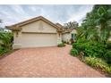 Tan house with beige garage door and manicured landscaping at 7117 Victoria Circle, University Park, FL 34201