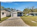 Newly built home with light gray siding, white garage door, and a brick paver driveway at 1006 Hagle Park Rd, Bradenton, FL 34212